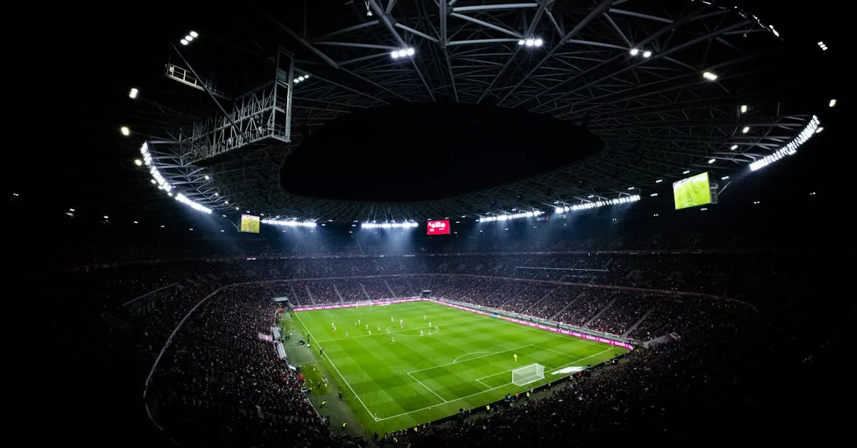 Football on a grass pitch under floodlights