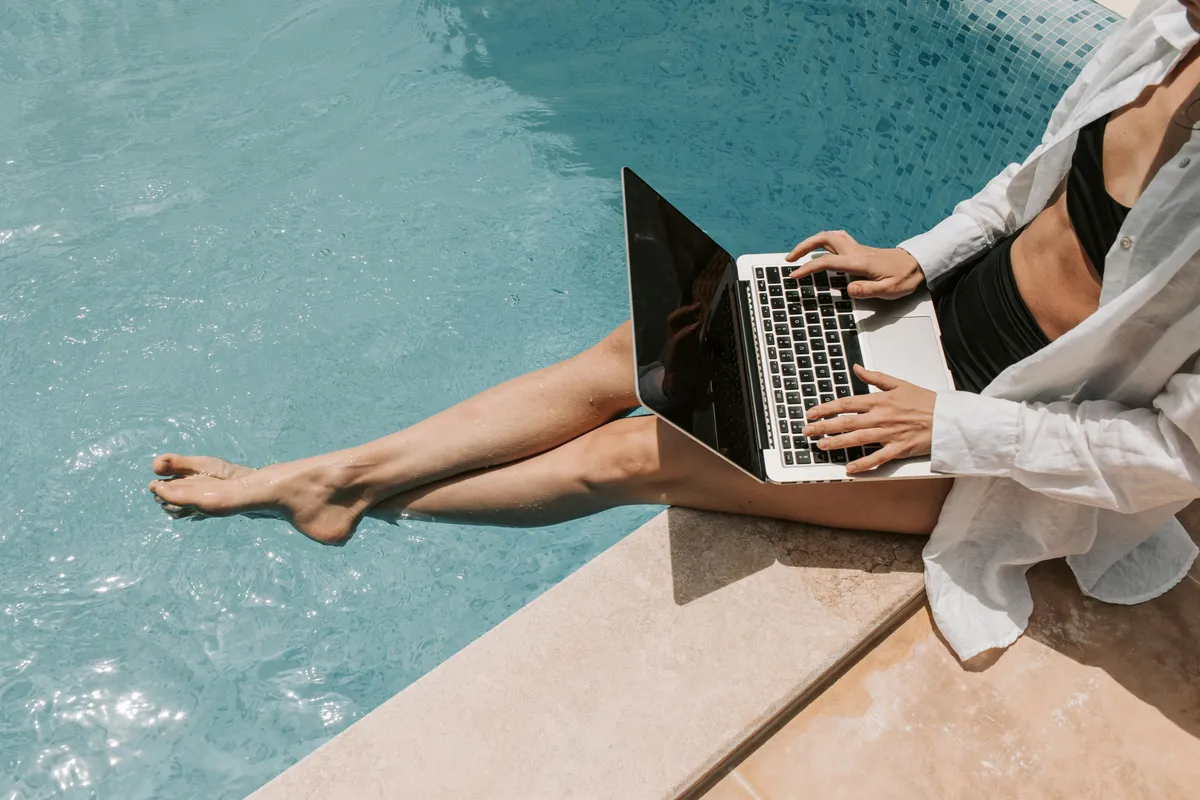 Digital nomad working with a laptop poolside